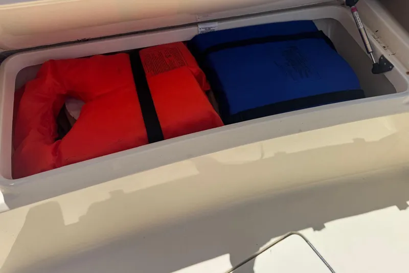 Slide: The Image of Storage compartment on 2013 Scout 275 LXF boat with red and blue life jackets. - 24