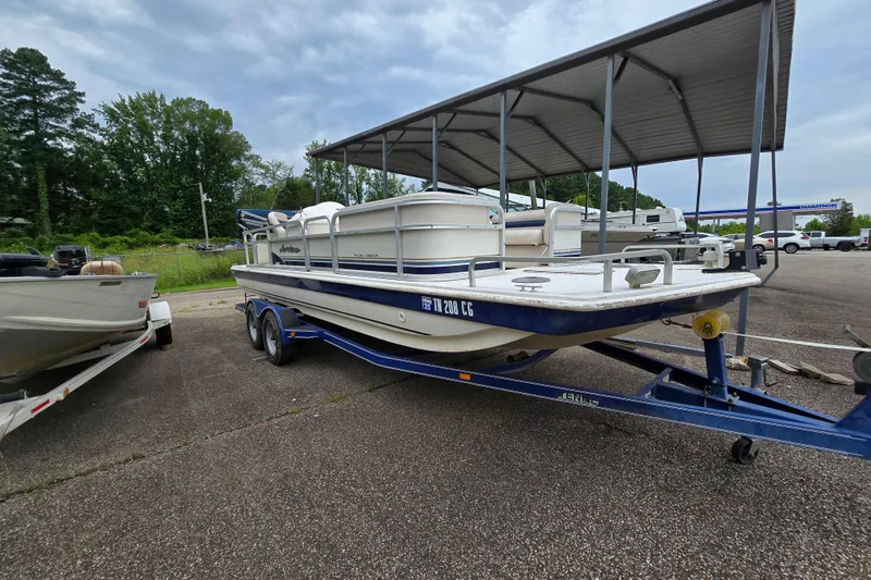 The Image of 1999 Hurricane 226R boat on trailer, parked outdoors under cloudy sky. - 1
