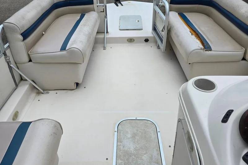 Slide: The Image of 1999 Hurricane 226R boat interior with worn seating and spacious deck area. - 5