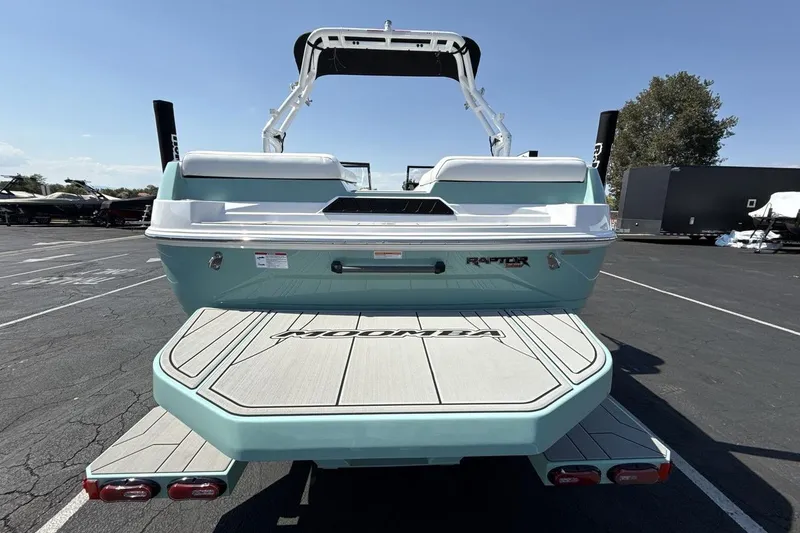Slide: The Image of 2026 Moomba Mondo boat rear view, featuring Raptor engine, in a parking lot. - 4