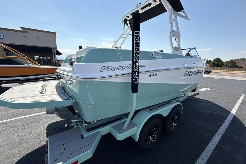 Slide: The Image of 2026 Moomba Mondo boat on trailer, light blue and white, parked outdoors. - 5