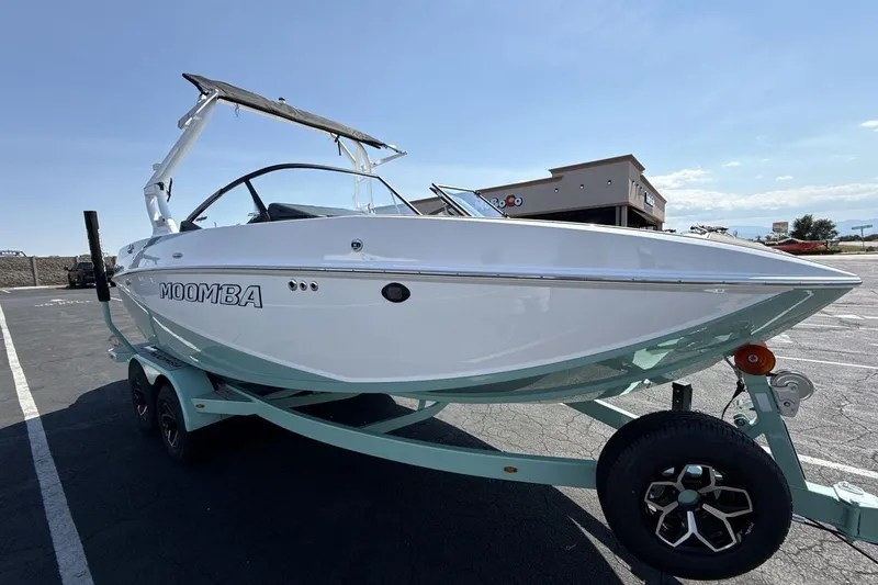 Slide: The Image of 2026 Moomba Mondo boat on trailer in parking lot, sunny day. - 7