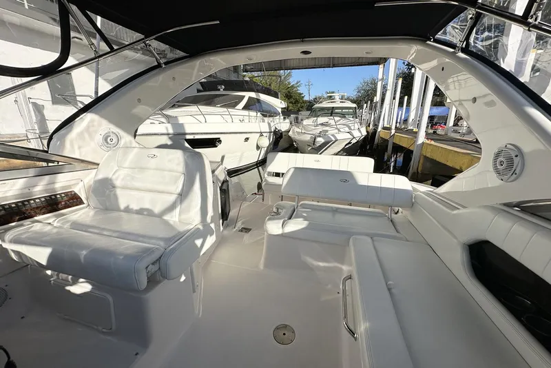 Slide: The Image of 2008 Regal 3360 Window Express boat interior with white seating and docked yachts in background. - 16