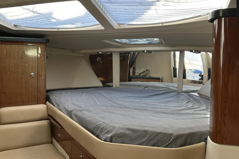 Slide: The Image of Interior cabin of 2008 Regal 3360 Window Express yacht with striped bedding. - 18