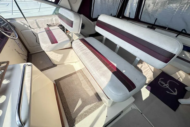 Slide: The Image of 1987 Sea Ray 340 Sundancer interior with white and maroon seating, helm area view. - 10
