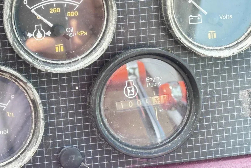 Slide: The Image of Dashboard gauges of a 1987 Sea Ray 340 Sundancer boat, showing engine hours and oil pressure. - 13