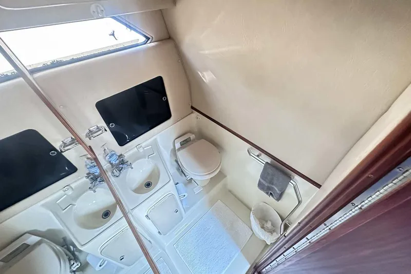 Slide: The Image of 1987 Sea Ray 340 Sundancer bathroom with sink, toilet, and mirror. - 19