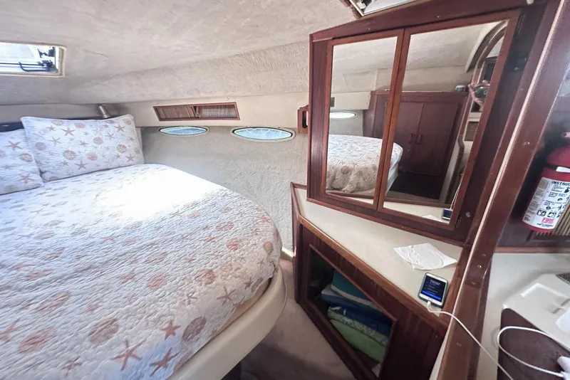 Slide: The Image of Cozy cabin interior of 1987 Sea Ray 340 Sundancer with bed, mirror, and storage. - 21