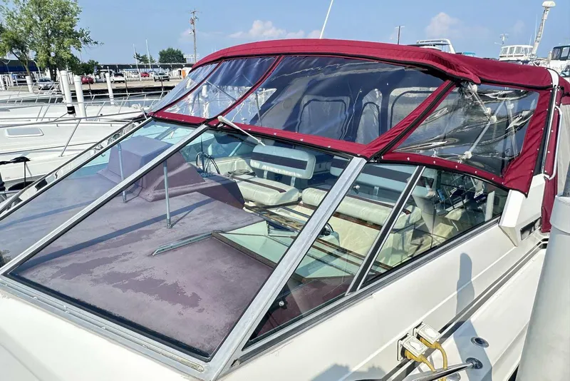 Slide: The Image of 1987 Sea Ray 340 Sundancer with maroon canopy docked at marina. - 4