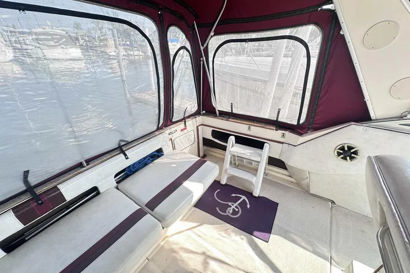 Slide: The Image of Interior of 1987 Sea Ray 340 Sundancer boat with seating and ladder, featuring maroon accents. - 7