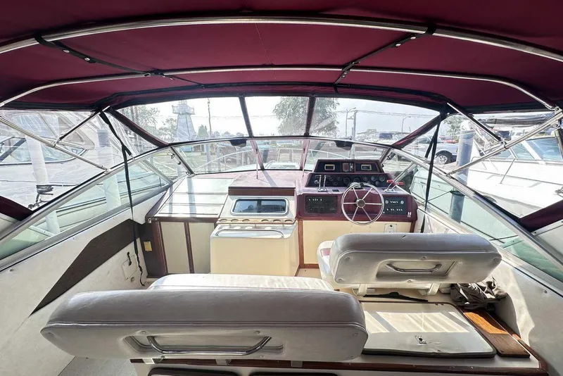 Slide: The Image of Interior view of 1987 Sea Ray 340 Sundancer boat with maroon canopy and helm controls. - 9