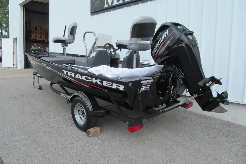 Slide: The Image of 2018 Tracker Pro 160 boat with Mercury engine on trailer, parked outside a building. - 3