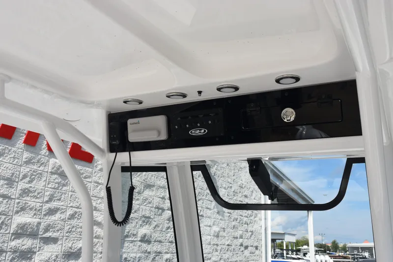 Slide: The Image of 2026 Sea Hunt Gamefish 27 console with Garmin electronics and overhead storage. - 11