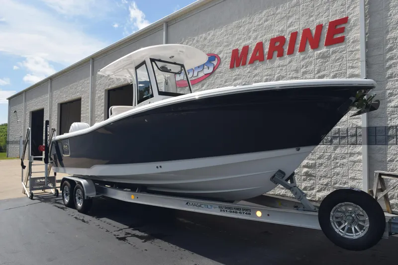 Slide: The Image of 2026 Sea Hunt Gamefish 27 Forward Seating boat on trailer outside marine dealership. - 2