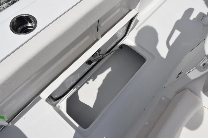 Slide: The Image of 2026 Sea Hunt Gamefish 27 Forward Seating storage compartment with open hatch and cup holder. - 25