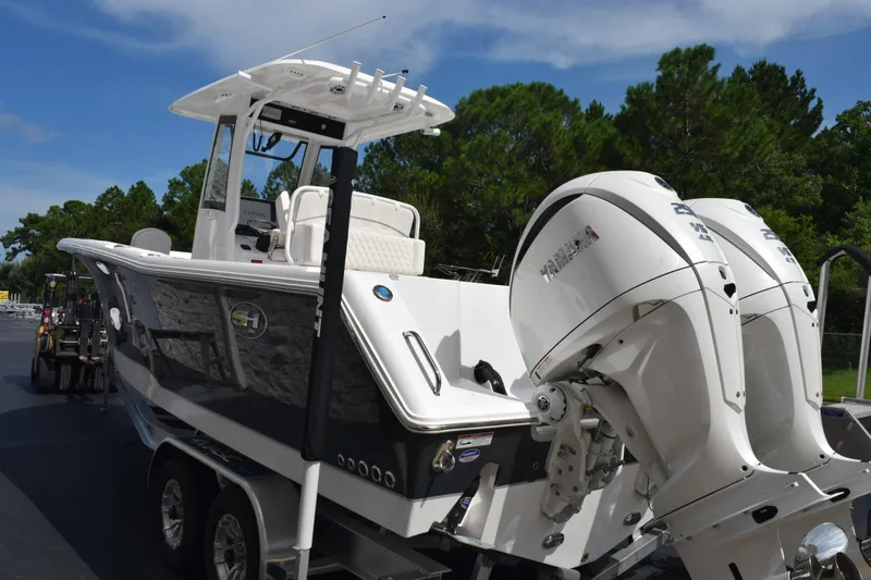 Slide: The Image of 2026 Sea Hunt Gamefish 27 boat with dual Yamaha engines on a trailer. - 6