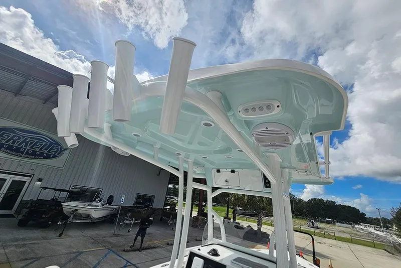 Slide: The Image of 2026 Sea Pro 225 Sandbar boat with rod holders and speakers under a blue sky. - 33