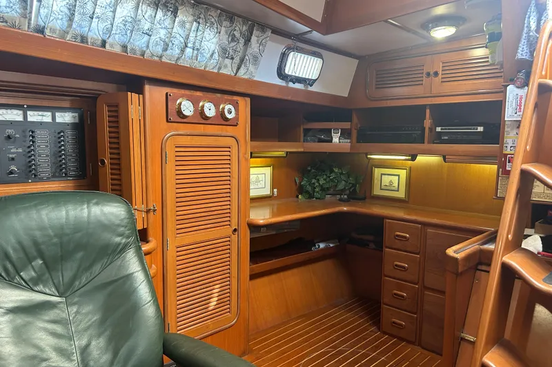 Slide: The Image of Interior of 1995 Tayana 48 yacht with wooden cabinetry and green leather chair. - 12