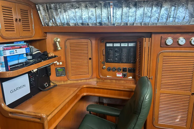 Slide: The Image of Navigation station of 1995 Tayana 48 yacht with control panel and books. - 14