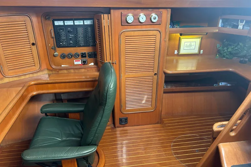 Slide: The Image of Interior of 1995 Tayana 48 yacht with wooden cabinetry and green leather chair. - 15