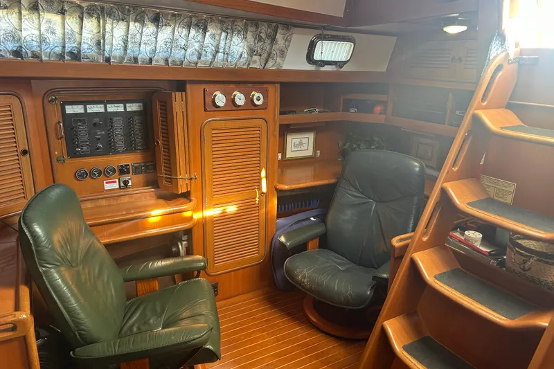 Slide: The Image of Interior of 1995 Tayana 48 yacht with leather chairs and wooden cabinetry. - 16