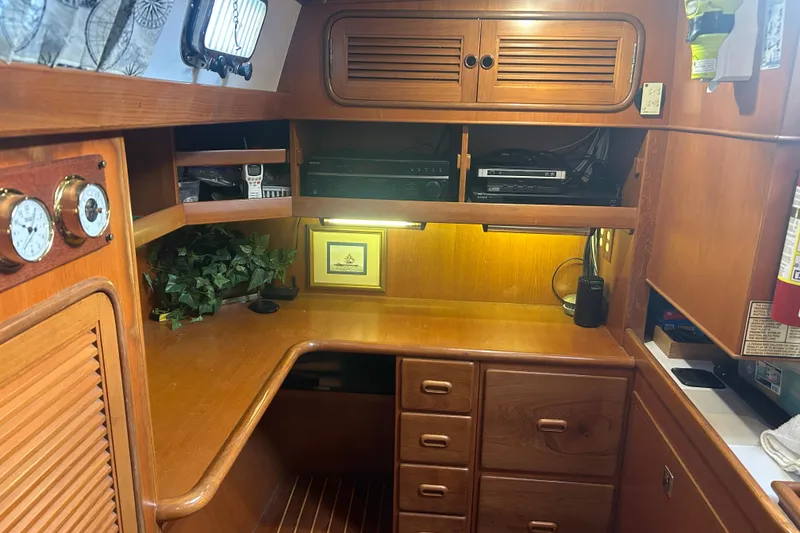 Slide: The Image of Cozy wooden interior of 1995 Tayana 48 yacht with desk, cabinets, and nautical decor. - 17