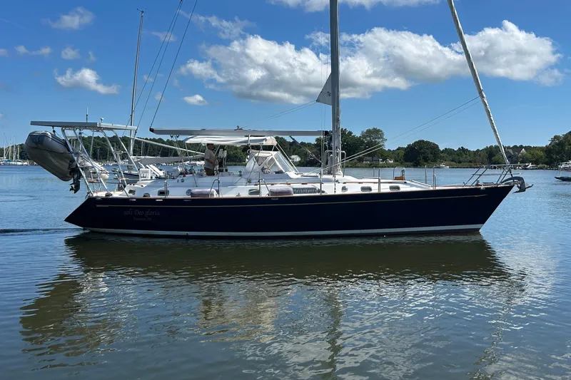 Slide: The Image of Sailing yacht Tayana 48, 1995 model, on calm water under a clear blue sky. - 2