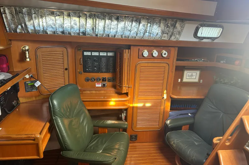 Slide: The Image of Interior of 1995 Tayana 48 yacht with wooden cabinetry and leather chairs. - 21