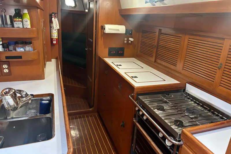 Slide: The Image of Interior of 1995 Tayana 48 yacht kitchen with stove, sink, and wooden cabinetry. - 22