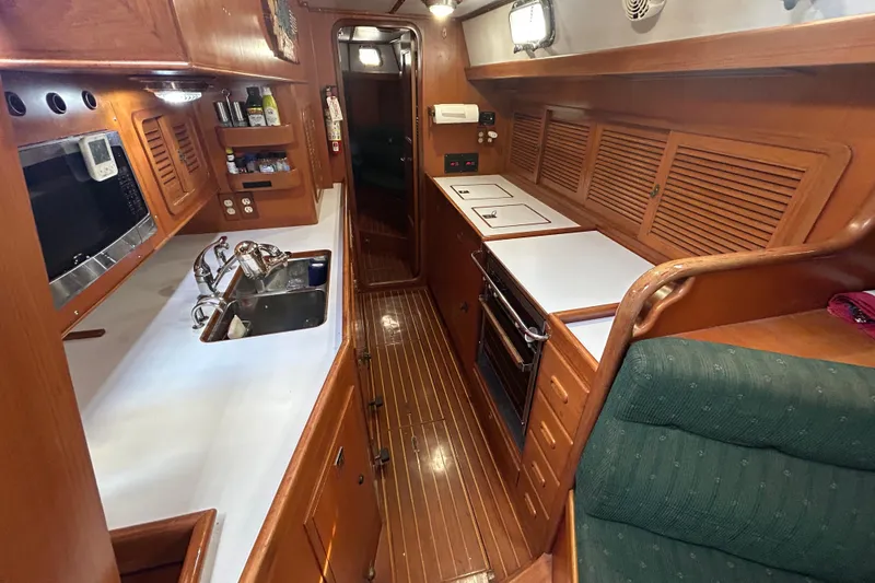 Slide: The Image of Interior of 1995 Tayana 48 yacht kitchen with wood finish and modern appliances. - 27