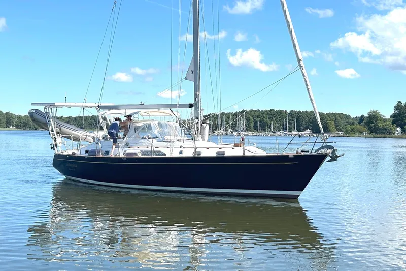 Slide: The Image of Sailing yacht Tayana 48, 1995 model, on calm waters under a clear blue sky. - 3