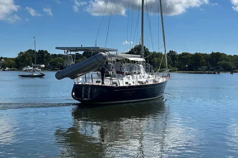 Slide: The Image of Sailing yacht Tayana 48, 1995 model, cruising on a calm lake under a clear blue sky. - 38