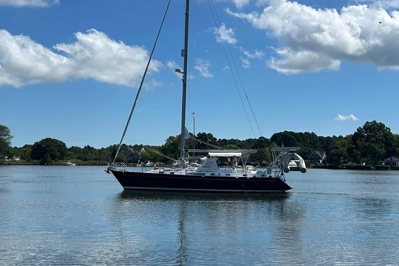 Slide: The Image of Sailboat Tayana 48, 1995 model, on calm water under a clear blue sky. - 39