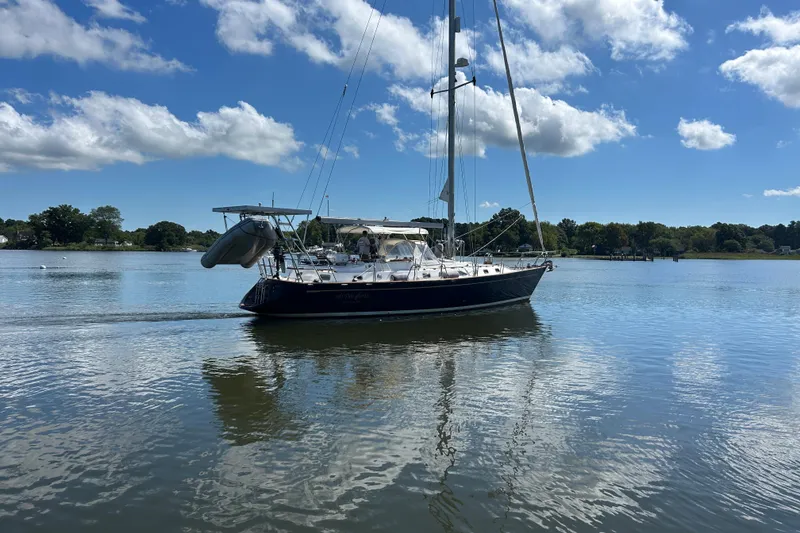 Slide: The Image of Sailboat on calm water, 1995 Tayana 48, under a clear blue sky. - 4