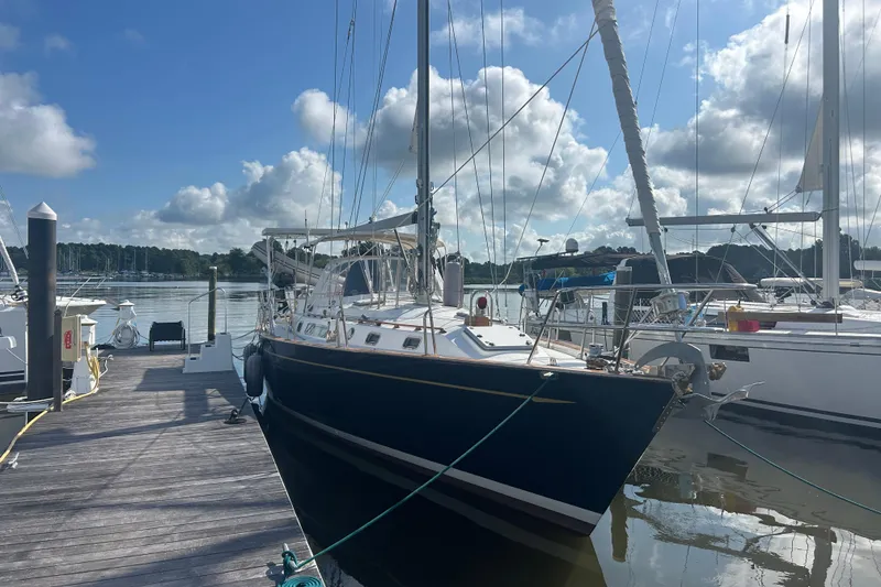 Slide: The Image of Sailboat docked at marina, Tayana 48 model, 1995, under a partly cloudy sky. - 6