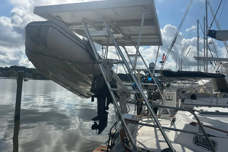 Slide: The Image of Sailboat Tayana 48 (1995) with dinghy and solar panels at marina. - 8