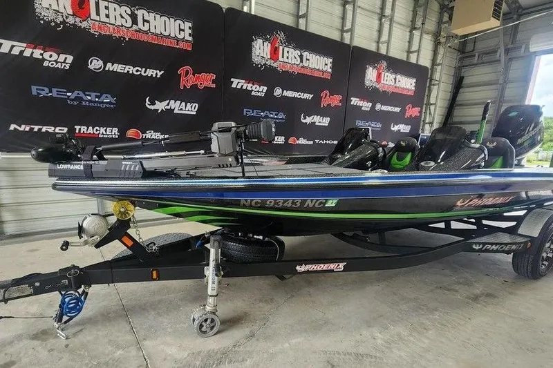 Slide: The Image of 2014 Phoenix 920 ProXP boat on trailer in showroom with promotional banners. - 8