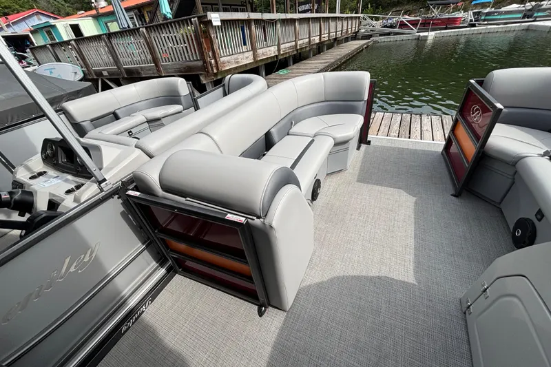 Slide: The Image of 2025 Bentley Pontoons Legacy Navigator with luxurious seating at a dockside view. - 7