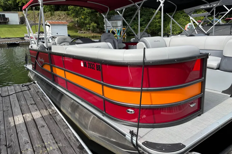 Slide: The Image of 2025 Bentley Pontoons Legacy Navigator docked, featuring vibrant red and orange design. - 8