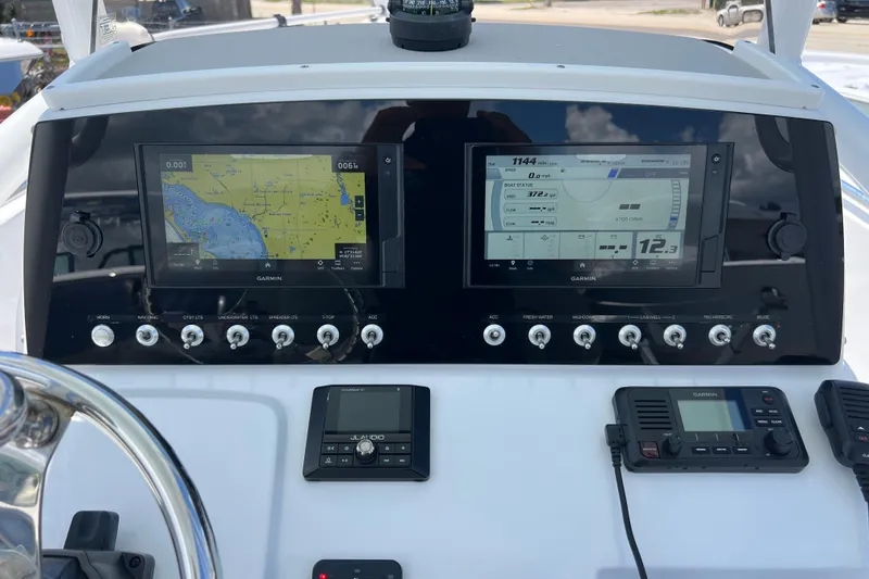 Slide: The Image of 2021 Sportsman Open 232 Center Console dashboard with Garmin navigation displays and controls. - 11