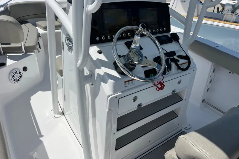 Slide: The Image of 2021 Sportsman Open 232 Center Console boat interior with steering wheel and control panel. - 9