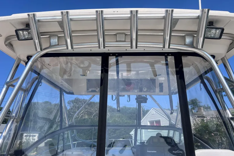Slide: The Image of 2007 Robalo R305 Walkaround boat with windshield and metal frame under clear blue sky. - 14