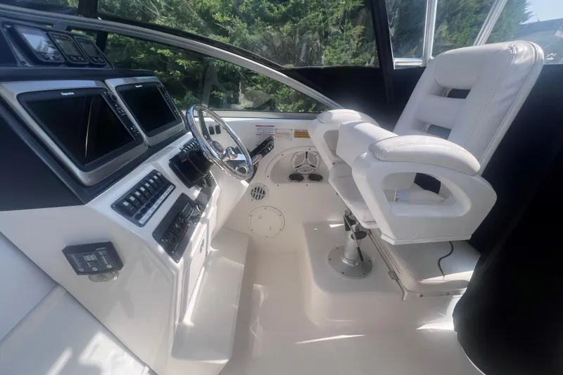 Slide: The Image of 2007 Robalo R305 Walkaround helm with dual screens and white captain's chair. - 15