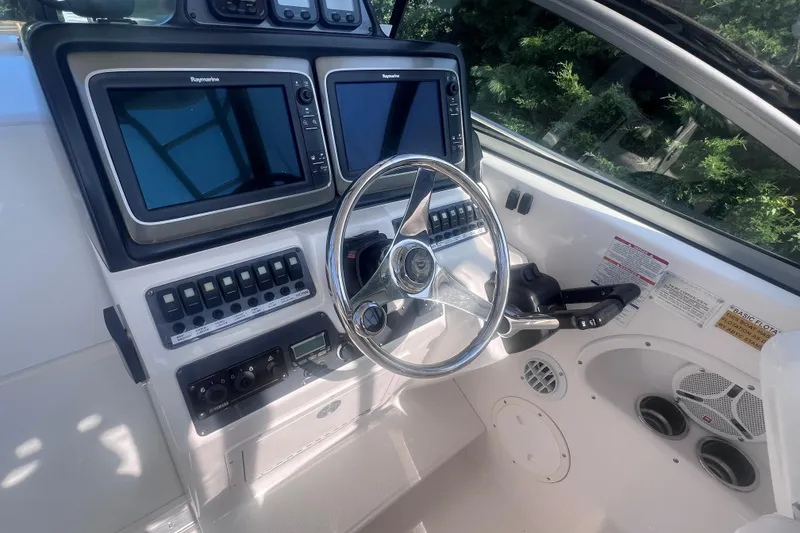 Slide: The Image of 2007 Robalo R305 Walkaround helm with dual Raymarine displays and control panel. - 16