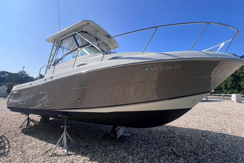 Slide: The Image of 2007 Robalo R305 Walkaround boat on stands, displayed outdoors on gravel. - 2