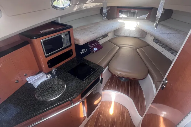 Slide: The Image of 2007 Robalo R305 Walkaround cabin interior with kitchenette and seating area. - 20
