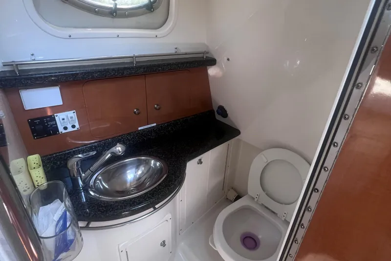 Slide: The Image of 2007 Robalo R305 Walkaround boat bathroom with sink, toilet, and storage cabinets. - 22
