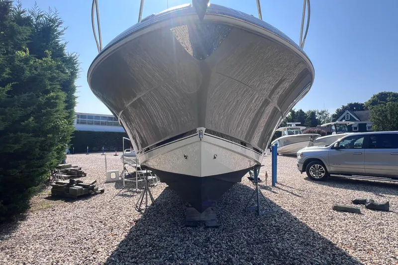 Slide: The Image of 2007 Robalo R305 Walkaround boat on dry dock, surrounded by vehicles and trees. - 23