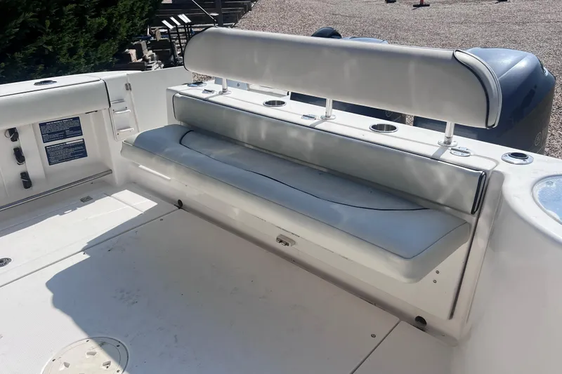 Slide: The Image of 2007 Robalo R305 Walkaround boat seating area with cushioned bench and cup holders. - 9
