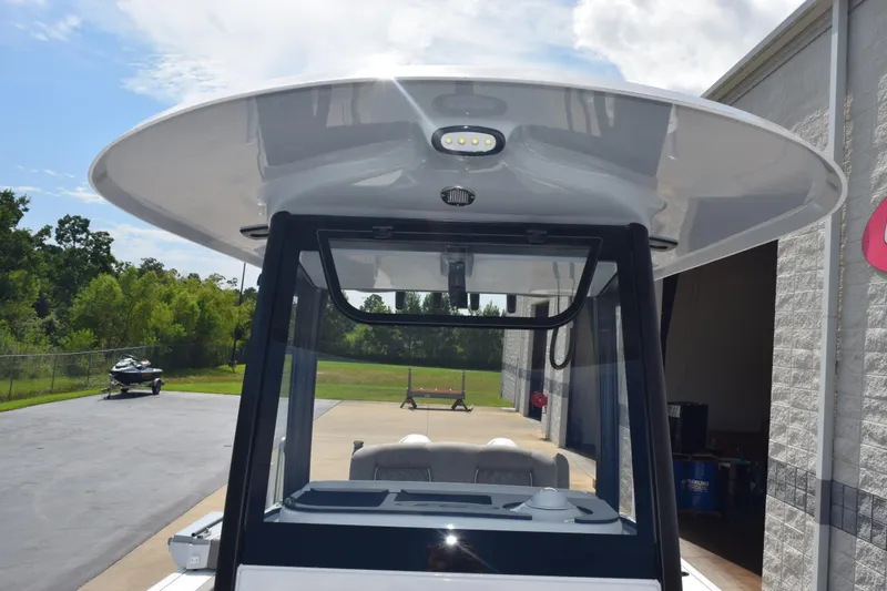 Slide: The Image of 2026 Sea Hunt Gamefish 25 boat with T-top and console, parked outdoors. - 15